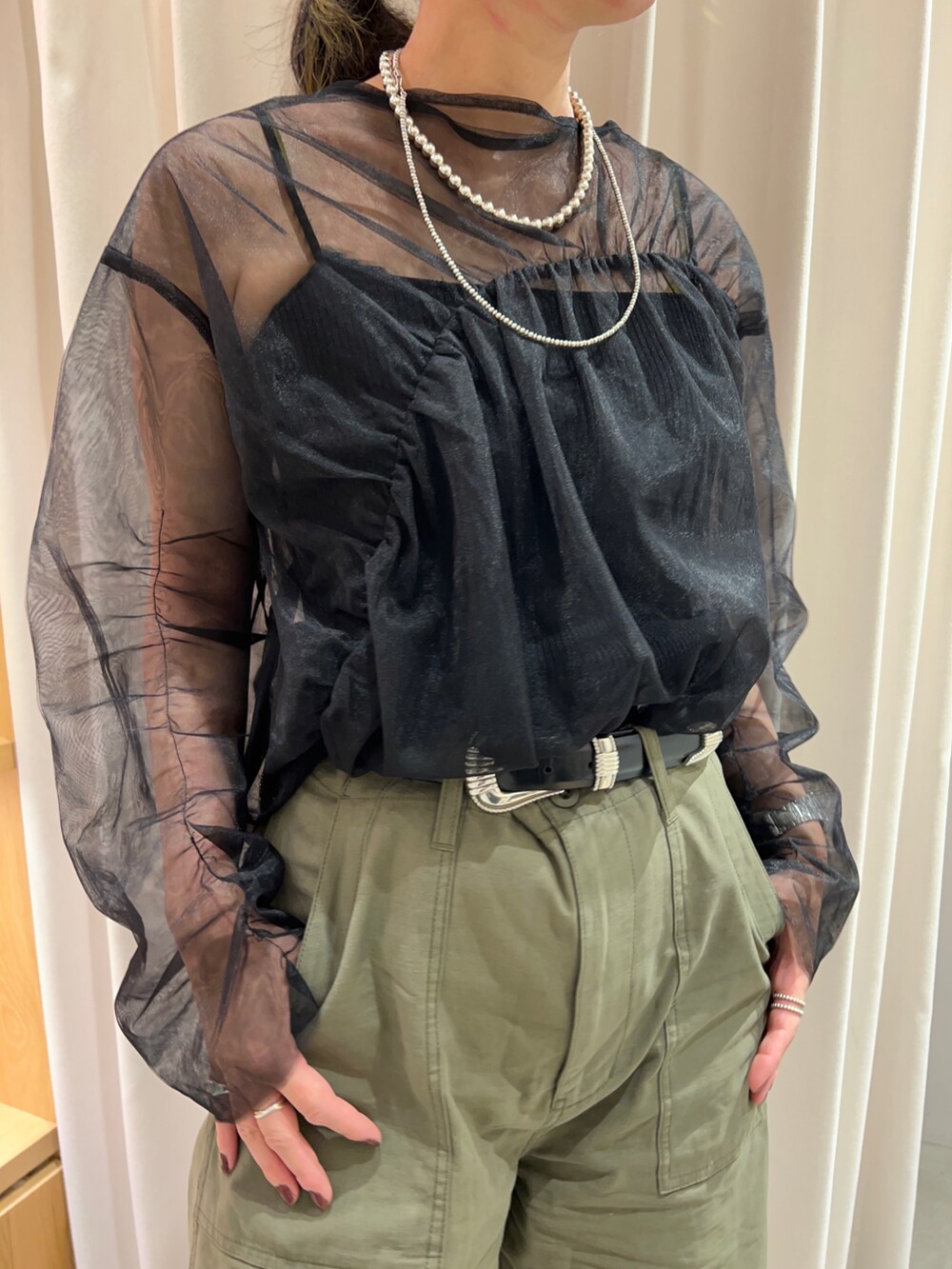 グリーン系のその他パンツ、ゴールド系のサンダル、ブラック系のシャツ/ブラウスを着用したレディースの夏コーディネートの2枚目の写真
