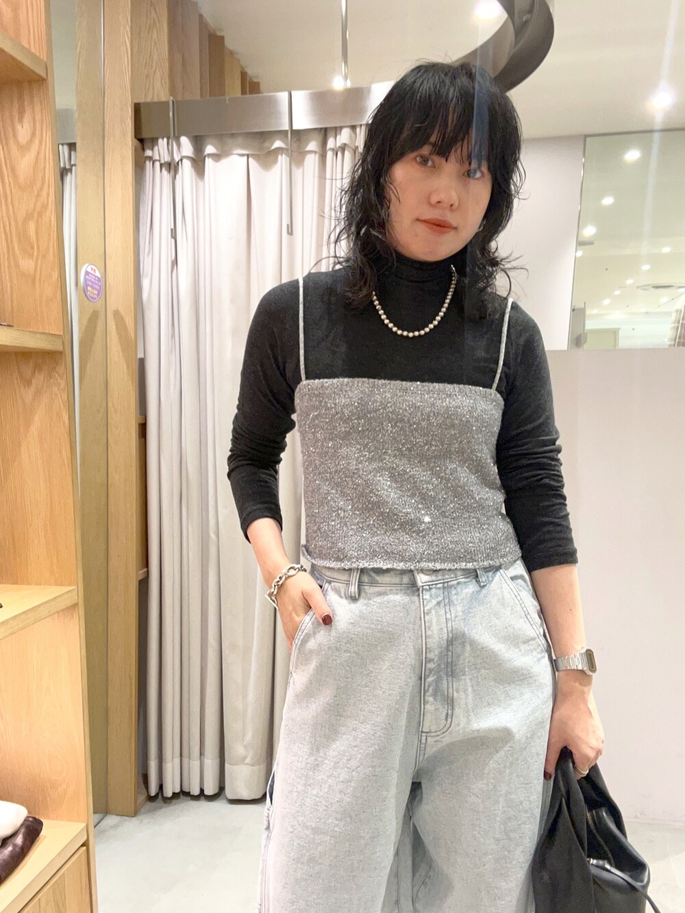 ブラック系のその他シューズ、ブルー系のデニムパンツ、ブラック系のバッグを着用したレディースの秋コーディネートの3枚目の写真