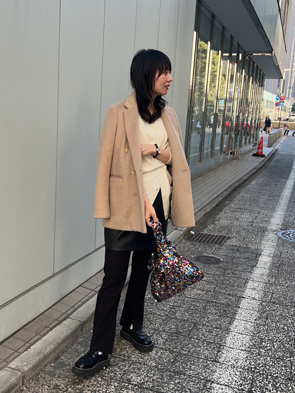 ブラック系のその他パンツ、ブラック系のスカート、ホワイト系のカーディガン/ボレロを着用したレディースの冬コーディネートの2枚目の写真