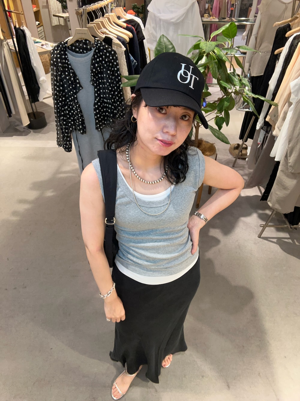 シルバー系のサンダル、ブラック系のスカート、グレー系のタンクトップを着用したレディースの夏コーディネートの3枚目の写真