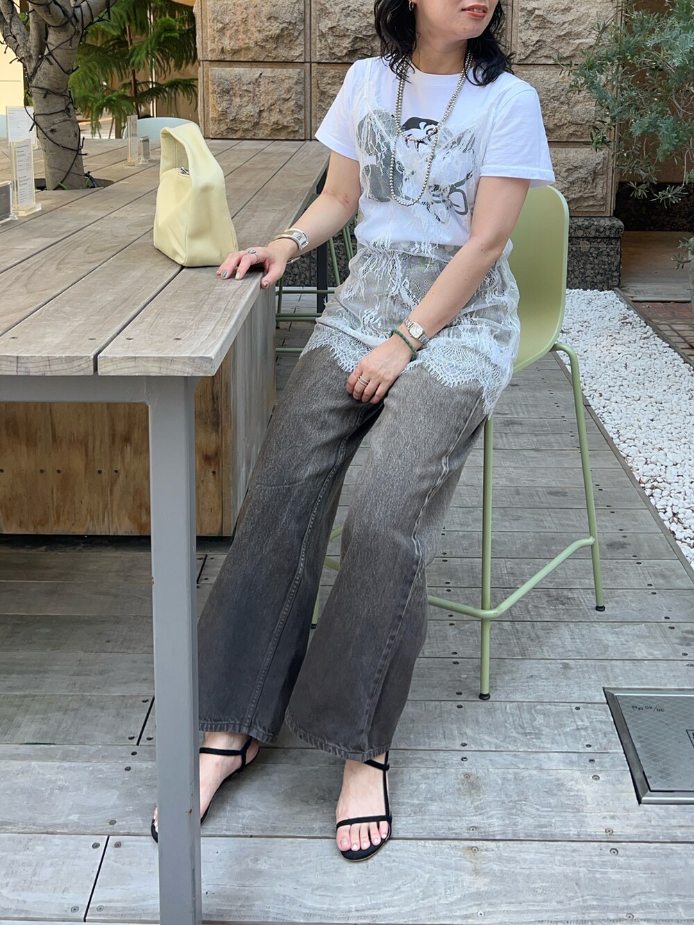 ホワイト系のシャツ/ブラウス、イエロー系のトートバッグ、ブラウン系のデニムパンツを着用したレディースの夏コーディネートの2枚目の写真