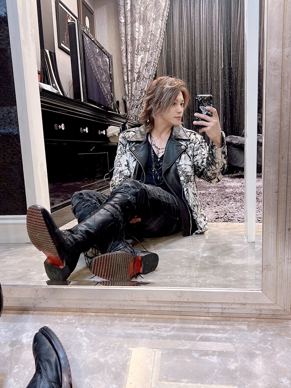 ブラック系のピーコート、ブラック系のデニムパンツ、ブラック系のブーツを着用したメンズの春コーディネートの2枚目の写真