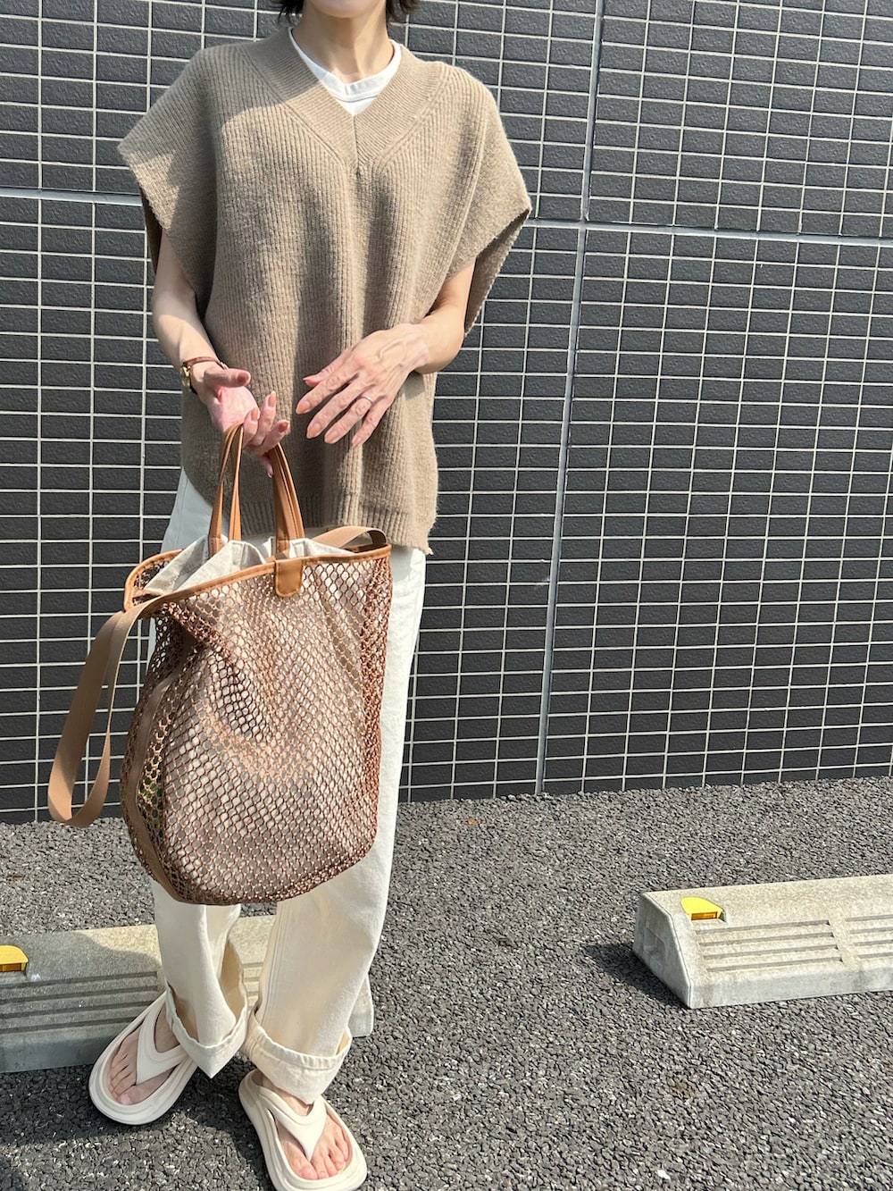 ホワイト系のデニムパンツ、イエロー系のショルダーバッグ、ホワイト系のサンダルを着用したレディースの夏コーディネートの2枚目の写真