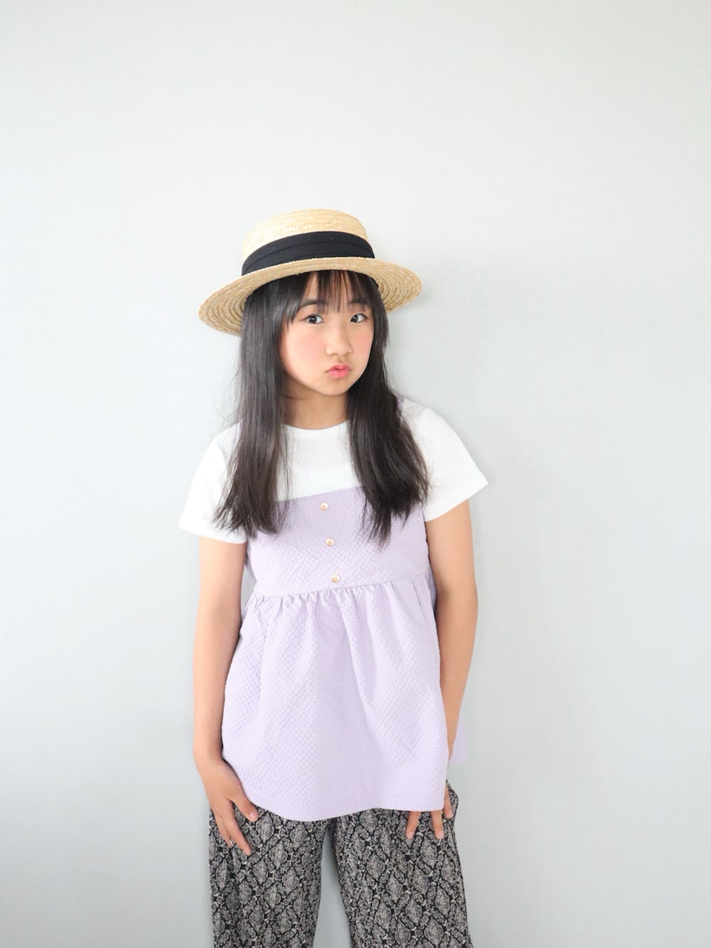 パープル系のTシャツ/カットソー、ブラック系のその他パンツ、ベージュ系のかごバッグを着用したキッズの夏コーディネートの4枚目の写真