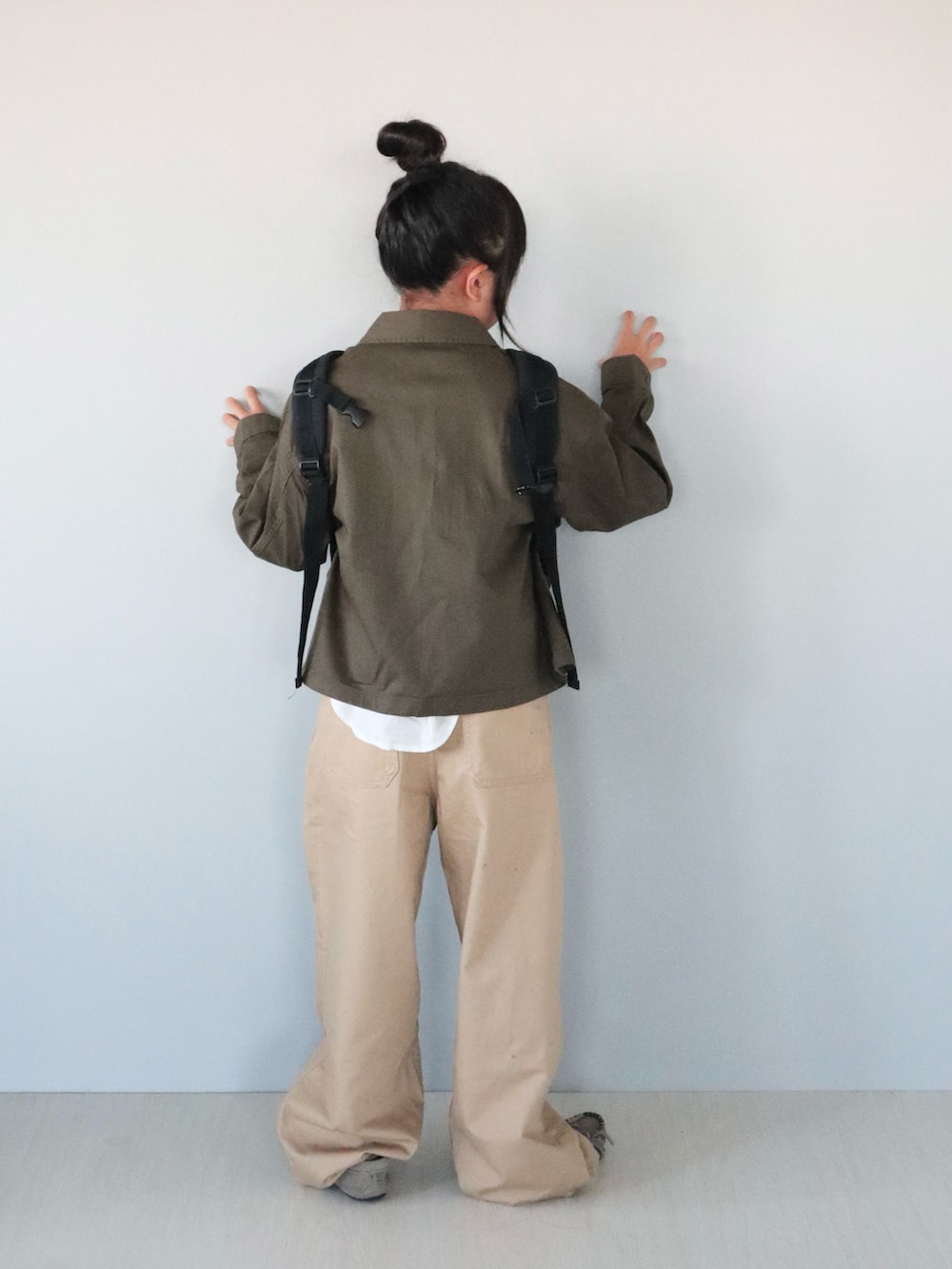 グレー系のモカシン/デッキシューズ、ホワイト系のシャツ/ブラウス、グリーン系のジャケット/アウターを着用したキッズの秋コーディネートの5枚目の写真