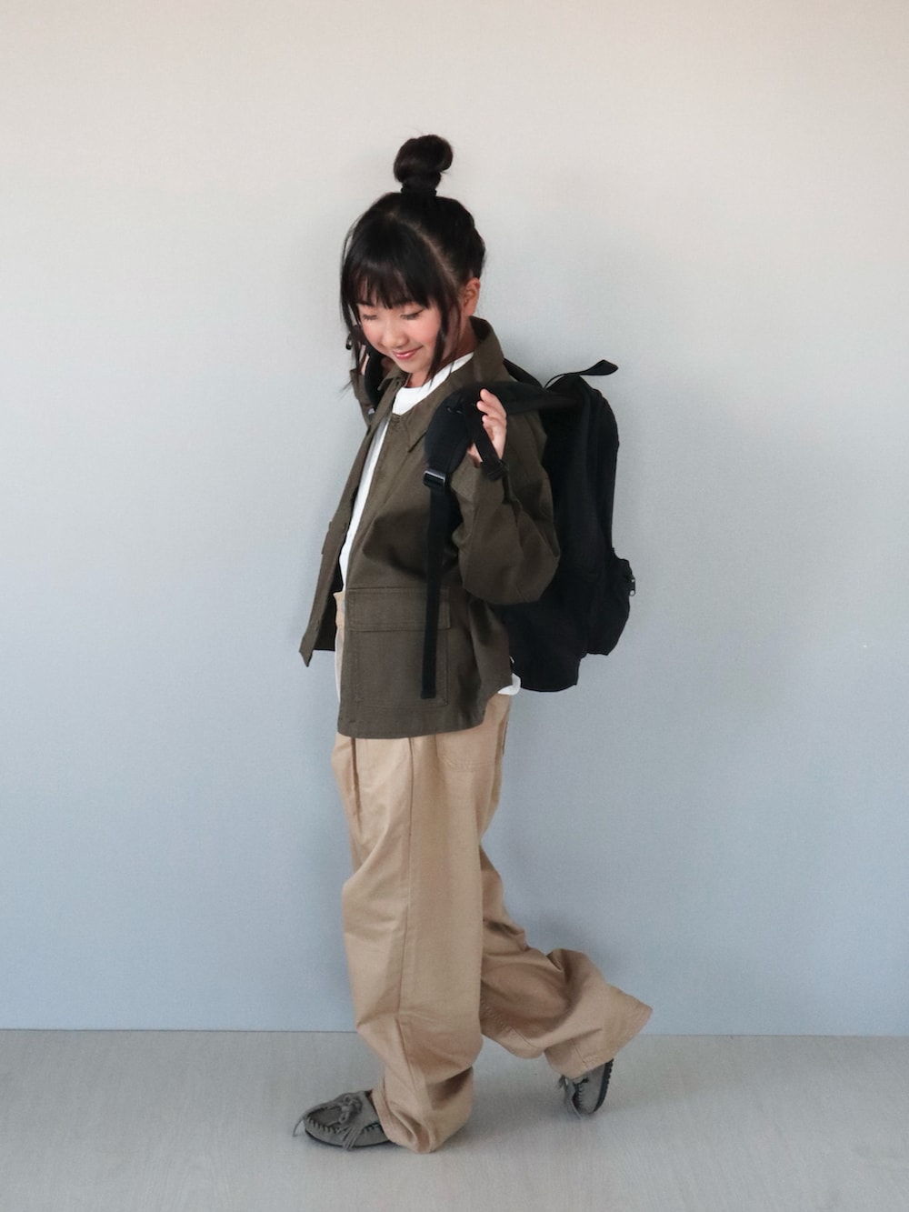 グレー系のモカシン/デッキシューズ、ホワイト系のシャツ/ブラウス、グリーン系のジャケット/アウターを着用したキッズの秋コーディネートの3枚目の写真