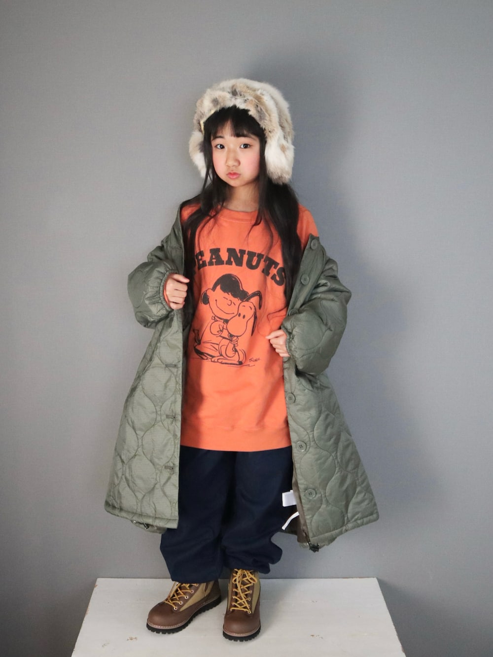 オレンジ系のトップス、ブルー系のパンツ、ブラウン系のシューズを着用したキッズの冬コーディネートの2枚目の写真