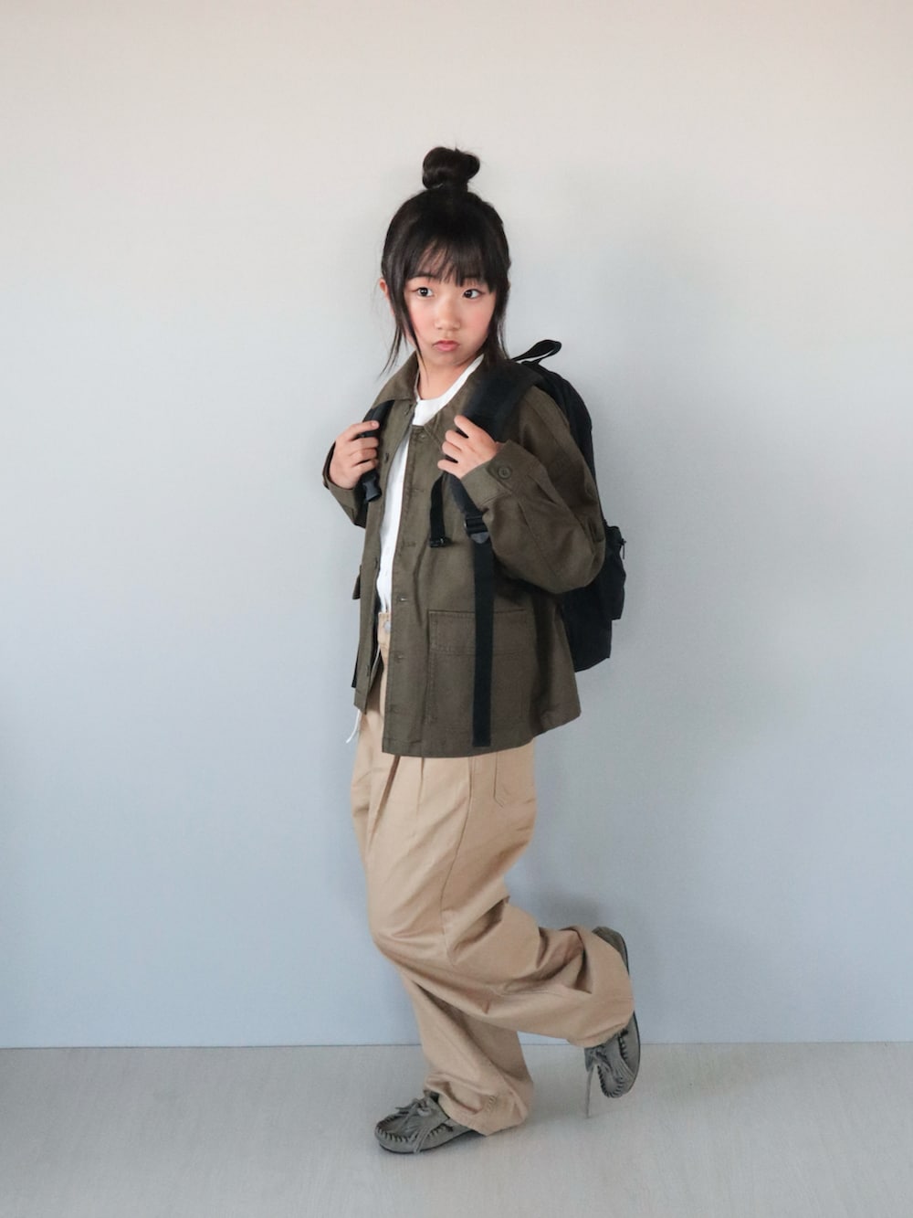 グレー系のモカシン/デッキシューズ、ホワイト系のシャツ/ブラウス、グリーン系のジャケット/アウターを着用したキッズの秋コーディネートの2枚目の写真