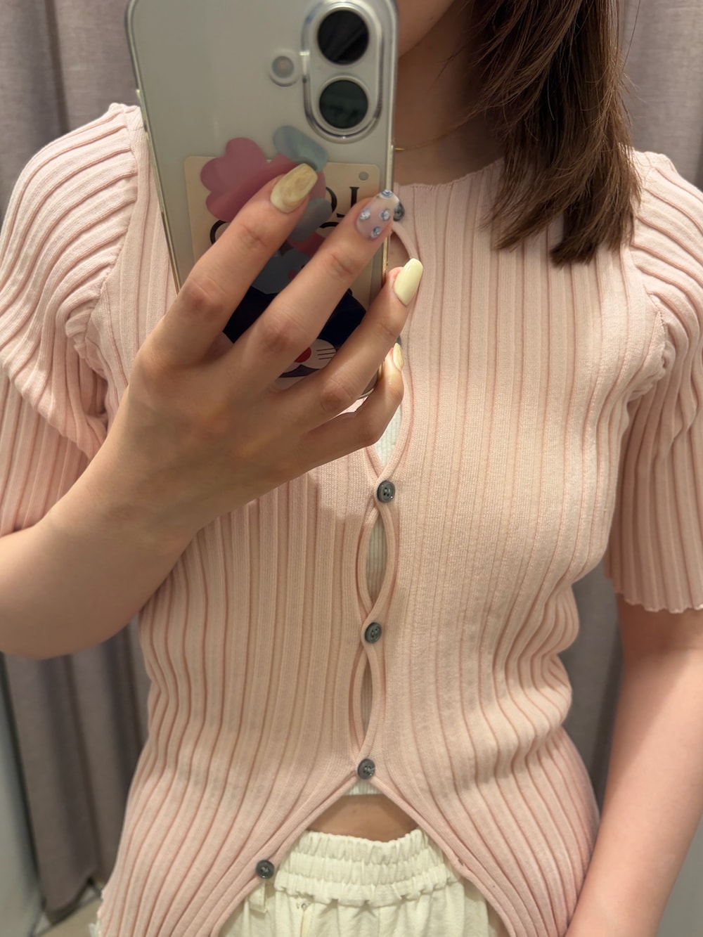 ホワイト系のスラックス、ピンク系のカーディガン/ボレロ、ブラック系のパンプスを着用したレディースの春コーディネートの2枚目の写真