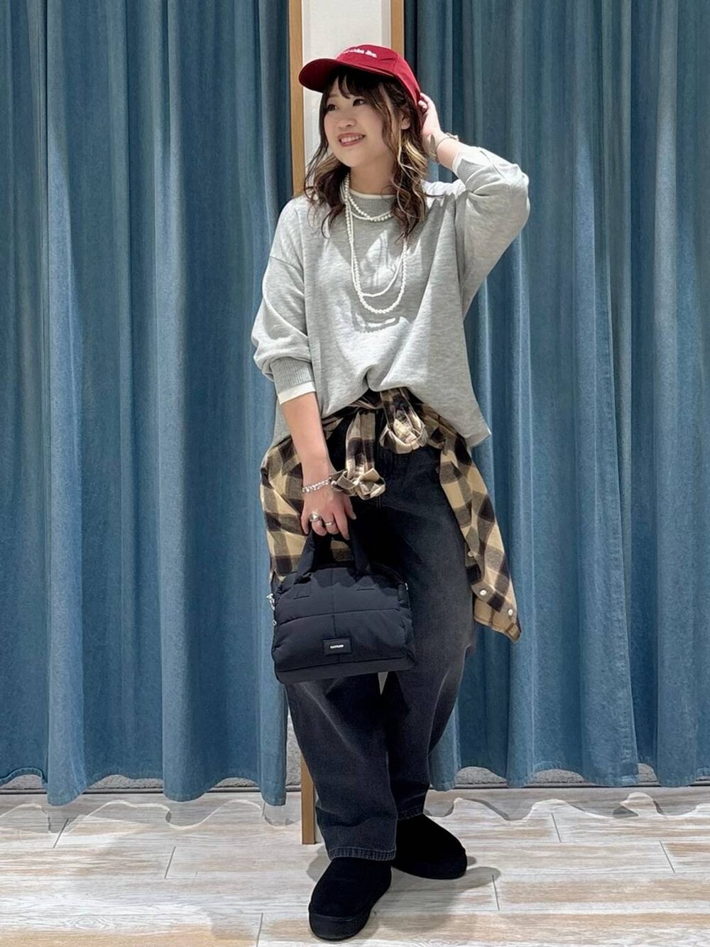 ブラック系のブーツ、グレー系のニット/セーター、ブラック系のボストンバッグを着用したレディースの秋コーディネートの4枚目の写真