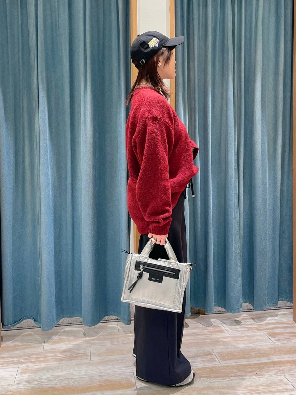 シルバー系のショルダーバッグ、ブラック系のその他パンツ、レッド系のニット/セーターを着用したレディースの冬コーディネートの2枚目の写真