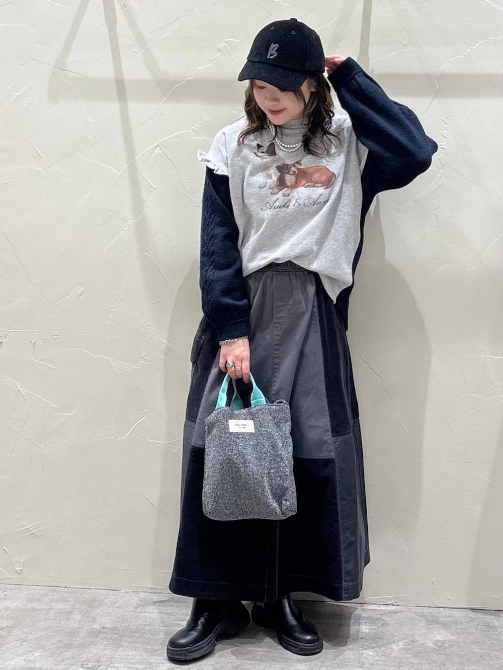 グレー系のスカート、シルバー系のトートバッグ、グレー系のニット/セーターを着用したレディースの冬コーディネートの4枚目の写真