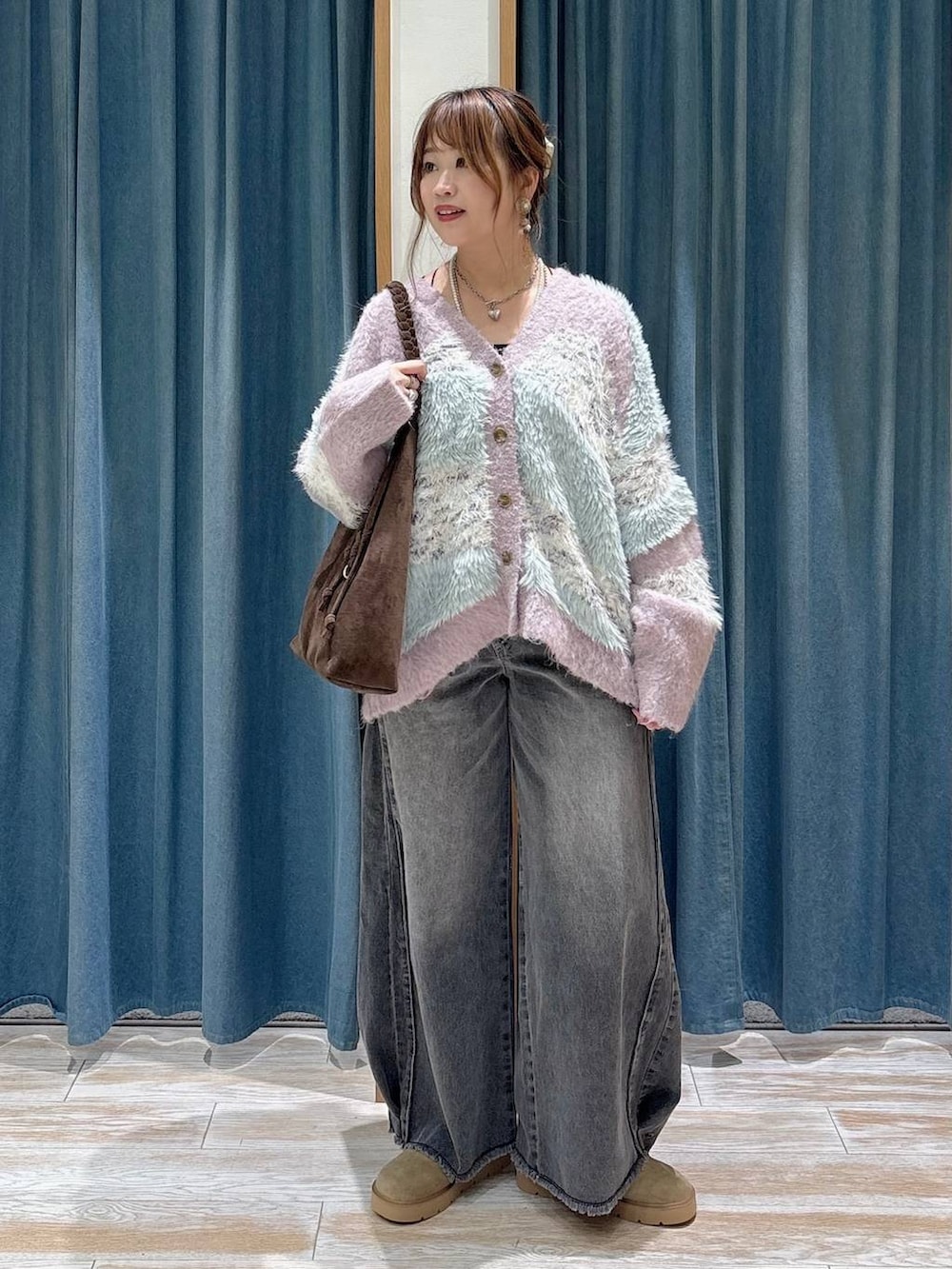 パープル系のカーディガン/ボレロ、ベージュ系のその他シューズ、ブラック系のデニムパンツを着用したレディースの秋コーディネートの4枚目の写真