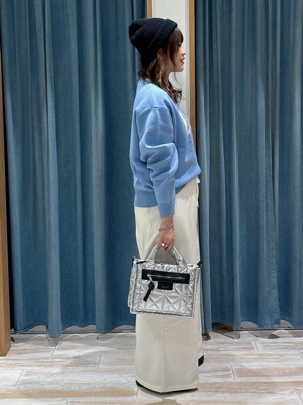 シルバー系のショルダーバッグ、ベージュ系のその他パンツ、ブルー系のニット/セーターを着用したレディースの秋コーディネートの2枚目の写真