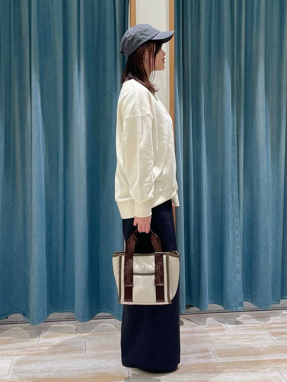 ホワイト系のブーツ、ブラック系のその他パンツ、ホワイト系のスウェットを着用したレディースの冬コーディネートの2枚目の写真