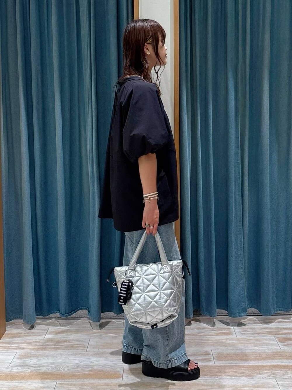 ブルー系のデニムパンツ、ブラック系のシャツ/ブラウス、ブラック系のサンダルを着用したレディースの夏コーディネートの2枚目の写真