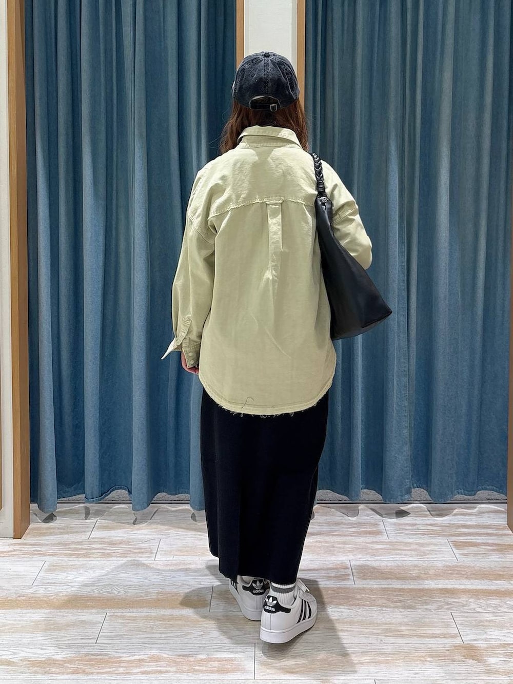 グリーン系のシャツ/ブラウス、ブラック系のスカート、グレー系のTシャツ/カットソーを着用したレディースの秋コーディネートの3枚目の写真