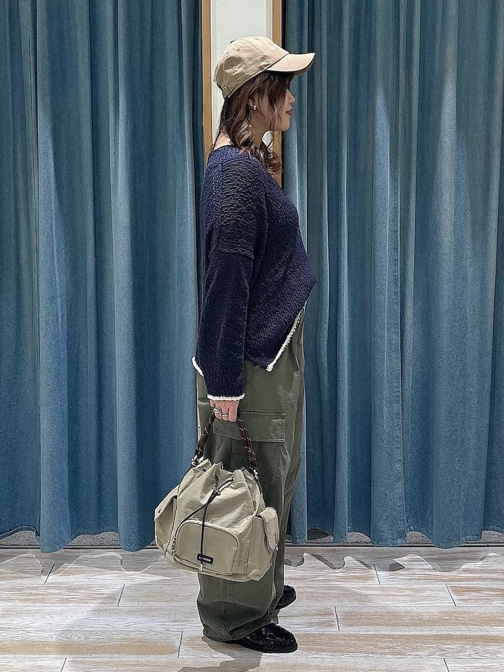 ブラック系のTシャツ/カットソー、ベージュ系のハンドバッグ、ブラック系のローファーを着用したレディースの冬コーディネートの2枚目の写真