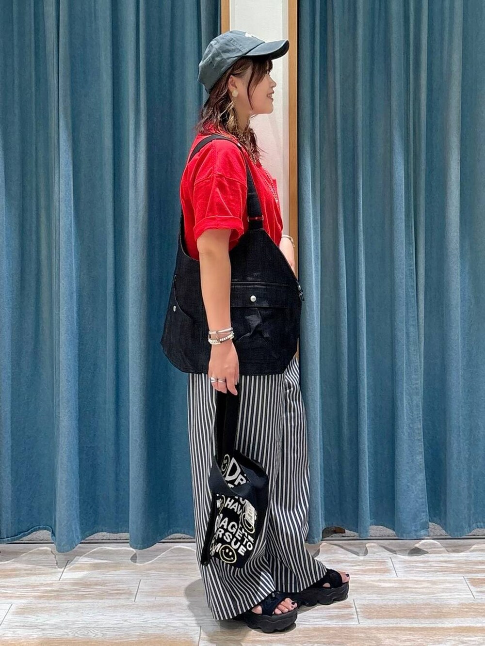 ブラック系のトートバッグ、レッド系のTシャツ/カットソー、その他のベストを着用したレディースの夏コーディネートの2枚目の写真