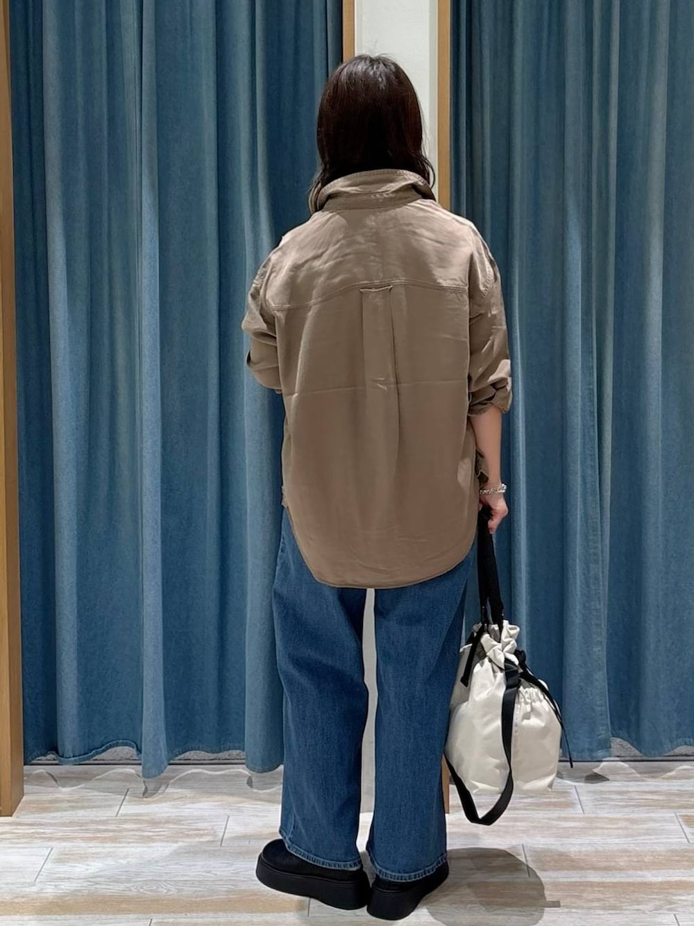 ブラック系のキャミソール、ホワイト系のトートバッグ、ブラウン系のシャツ/ブラウスを着用したレディースの秋コーディネートの3枚目の写真