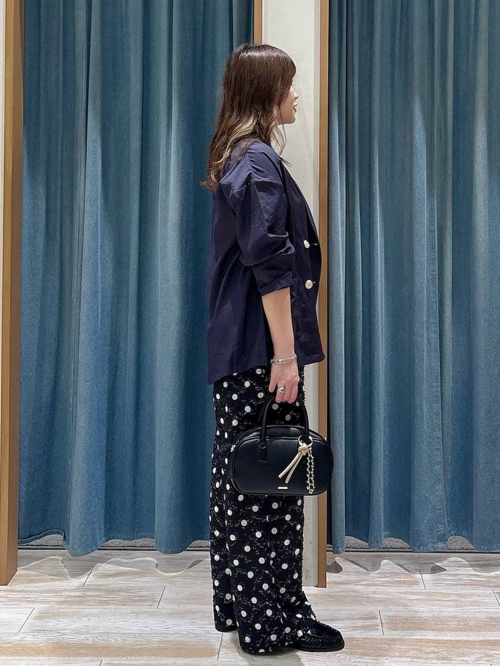 ブラック系のタンクトップ、ブラック系のローファー、ブラック系のハンドバッグを着用したレディースの春コーディネートの2枚目の写真