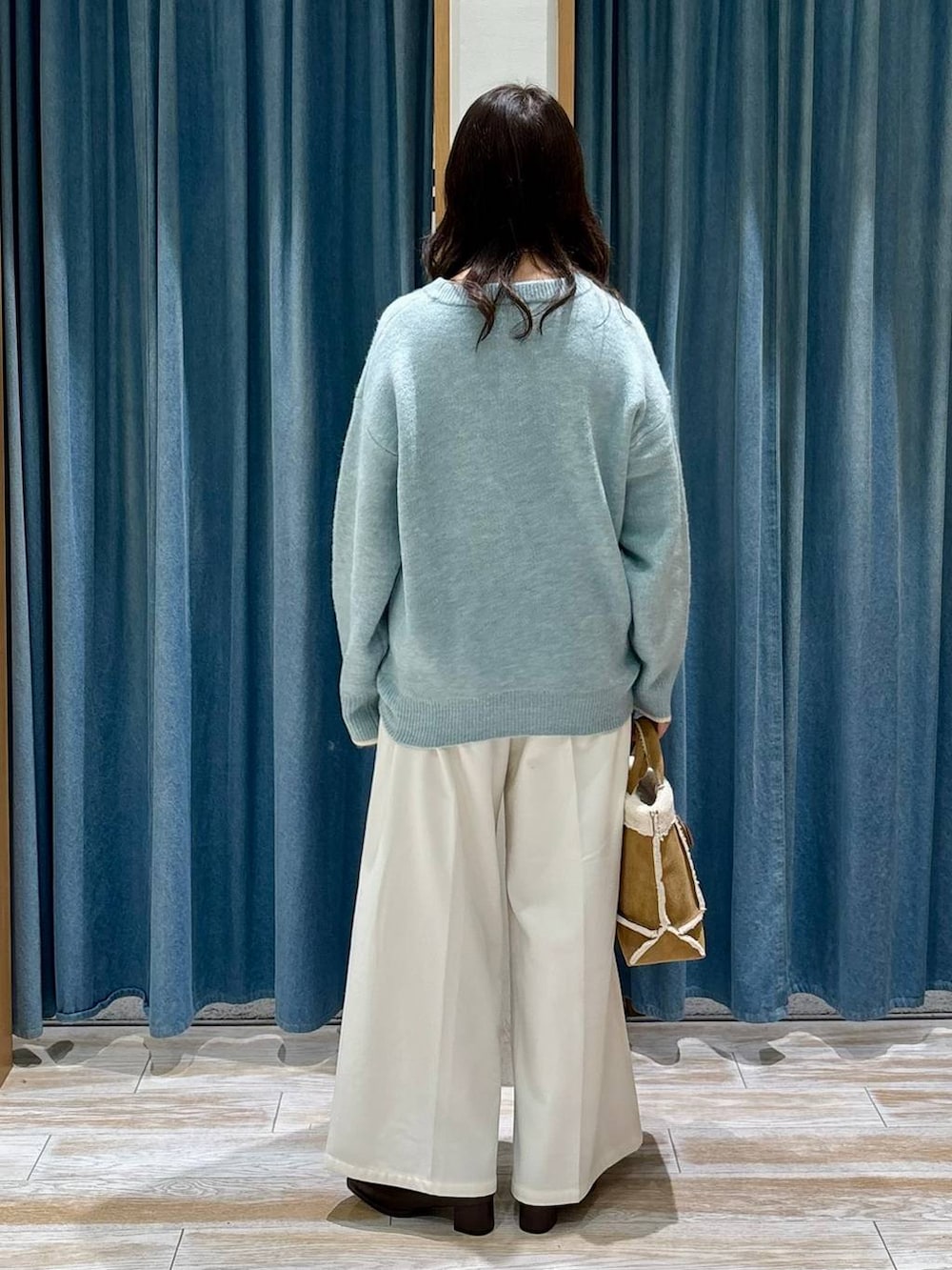 ベージュ系のその他パンツ、ブラウン系のブーツ、イエロー系のショルダーバッグを着用したレディースの冬コーディネートの3枚目の写真