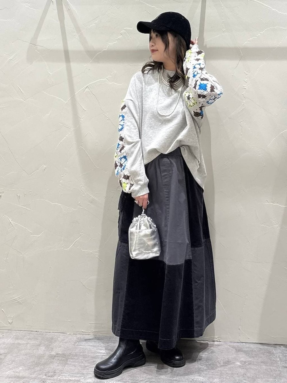 シルバー系のショルダーバッグ、グレー系のスウェット、グレー系のスカートを着用したレディースの冬コーディネートの4枚目の写真