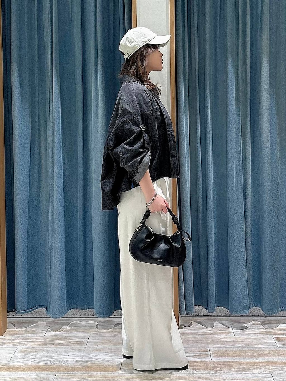 ブラック系のハンドバッグ、ブラック系のローファー、ベージュ系のその他パンツを着用したレディースの春コーディネートの2枚目の写真