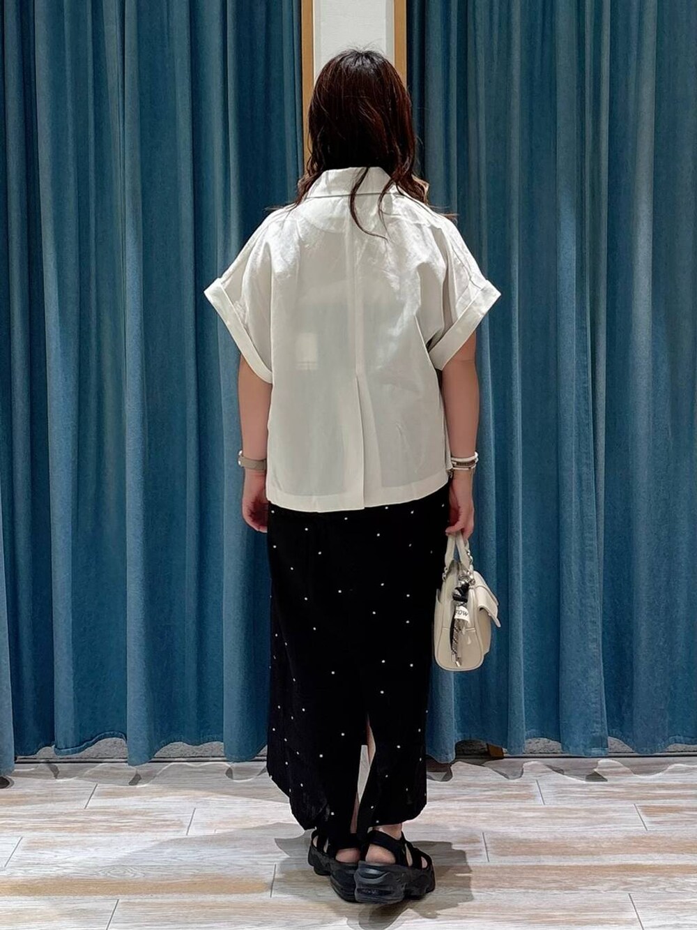 ホワイト系のキャミソール、ベージュ系のその他アウター、ホワイト系のボストンバッグを着用したレディースの夏コーディネートの3枚目の写真