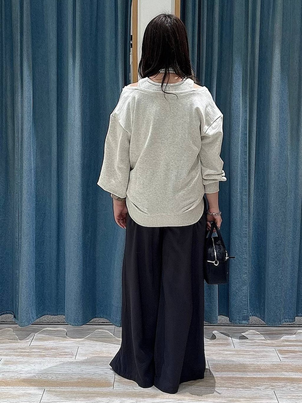 ブラック系のハンドバッグ、ブラック系のローファー、グレー系のその他パンツを着用したレディースの冬コーディネートの3枚目の写真