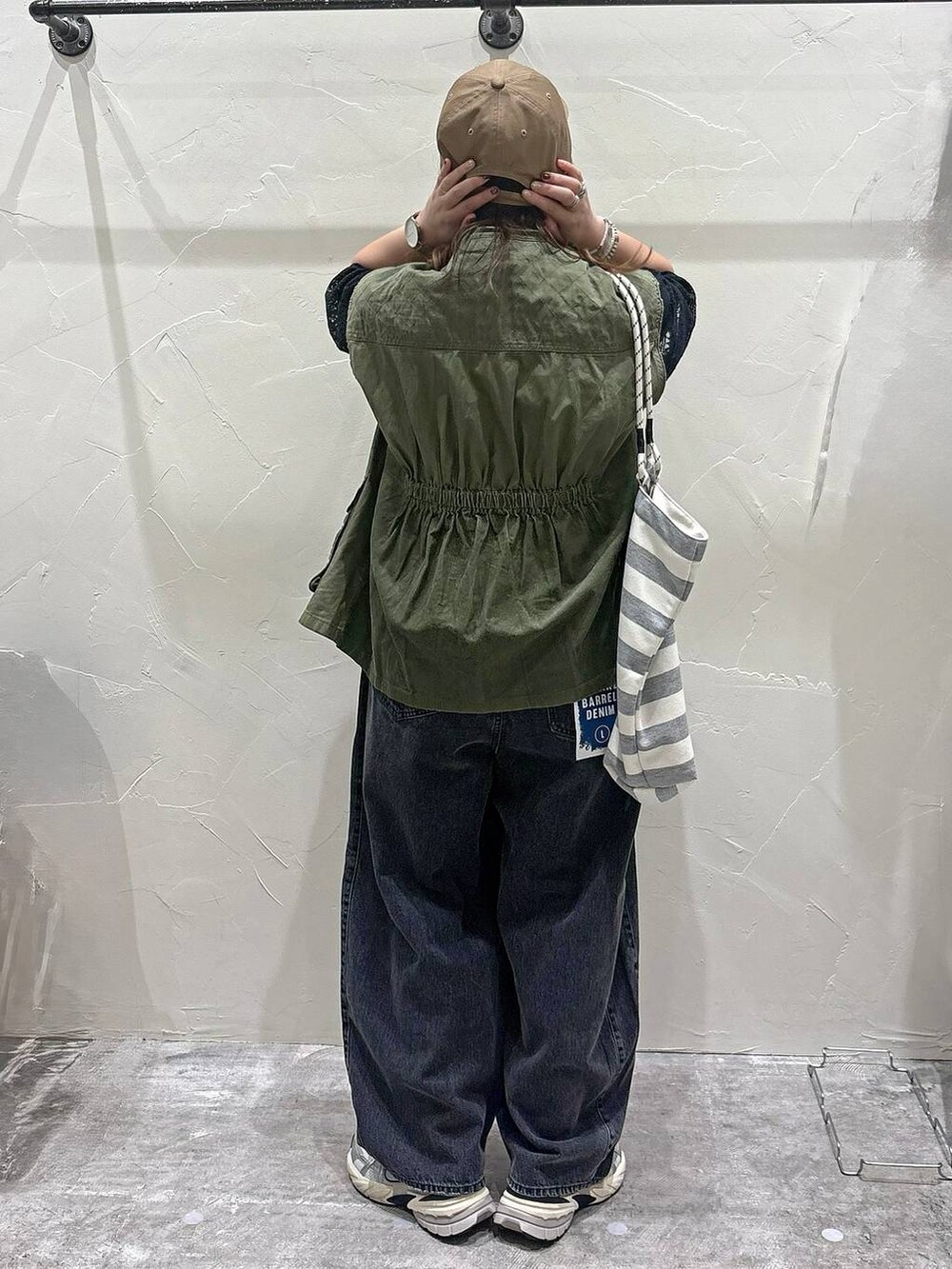 ホワイト系のトートバッグ、ブラック系のTシャツ/カットソー、グレー系のデニムパンツを着用したレディースの夏コーディネートの3枚目の写真