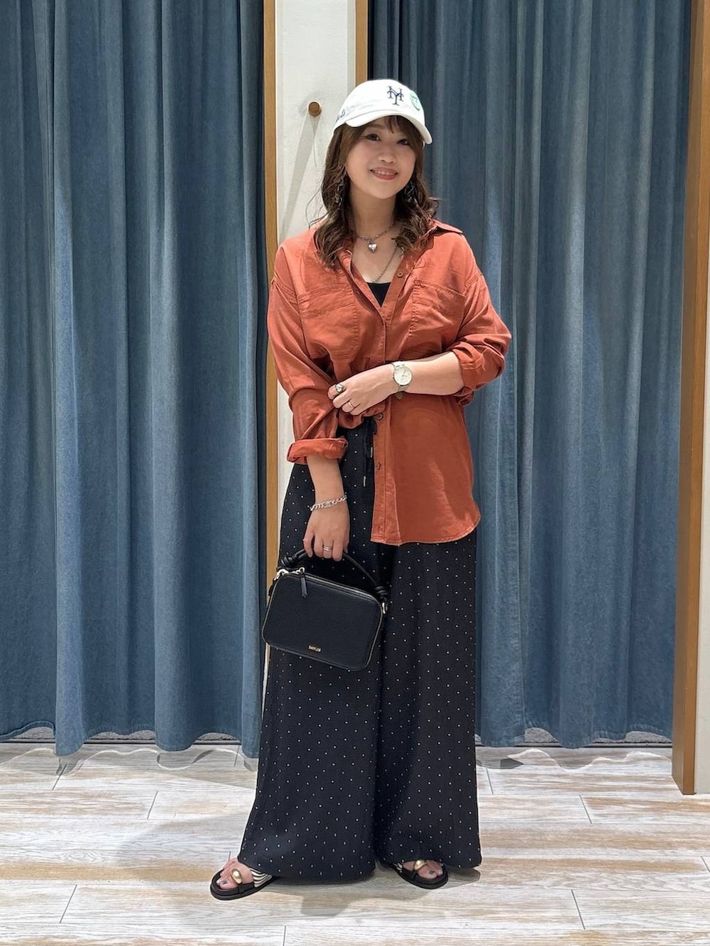 その他のサンダル、ブラウン系のシャツ/ブラウス、ブラック系のハンドバッグを着用したレディースの夏コーディネートの4枚目の写真
