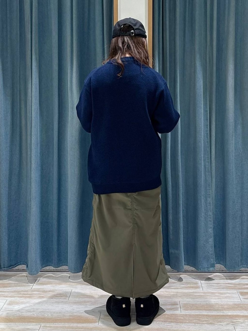 グリーン系のスカート、ブラック系のブーツ、ブルー系のニット/セーターを着用したレディースの秋コーディネートの3枚目の写真