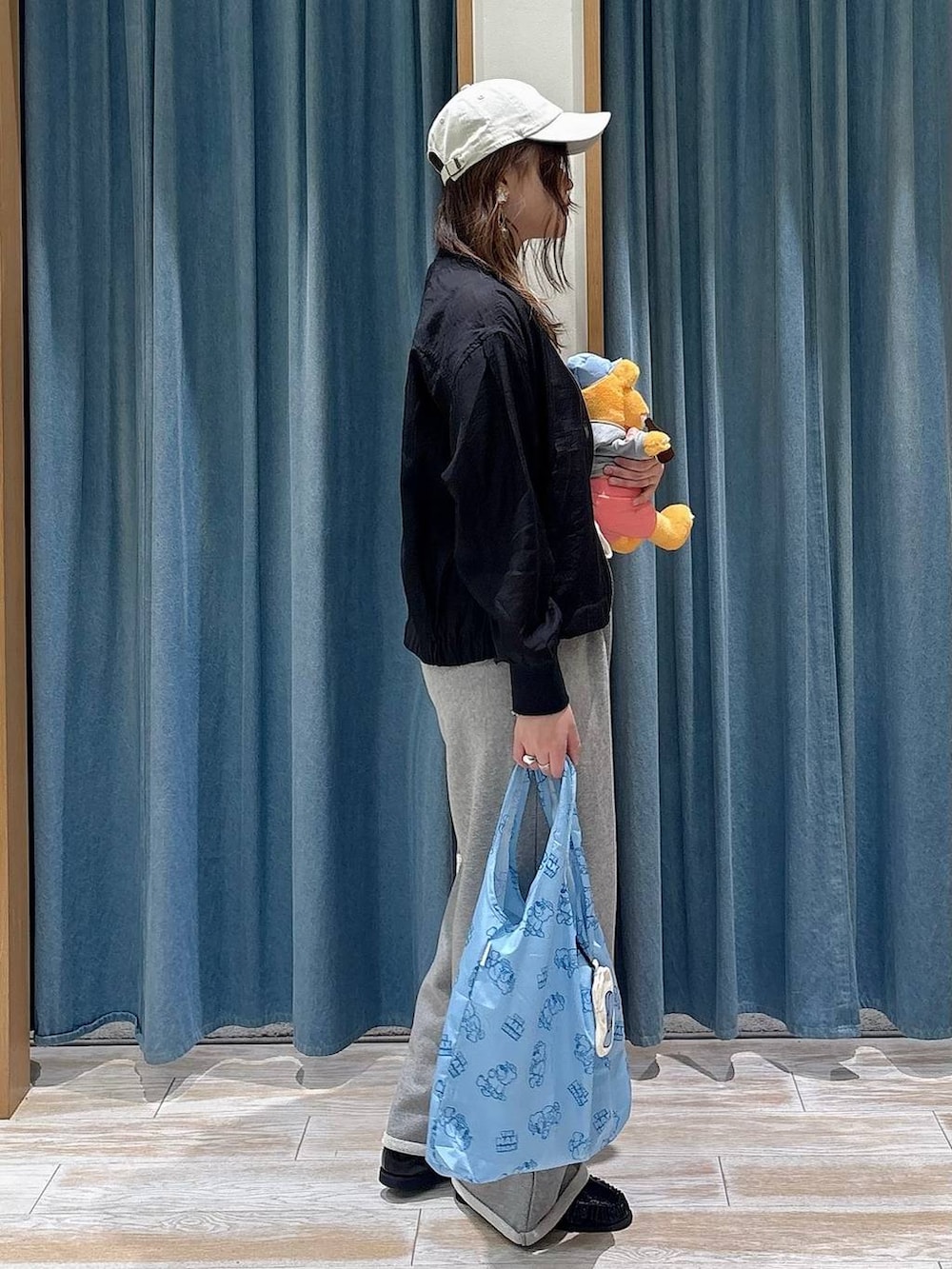 ブラック系のローファー、ブルー系のエコバッグ/サブバッグ、ブラック系のブルゾンを着用したレディースの春コーディネートの2枚目の写真