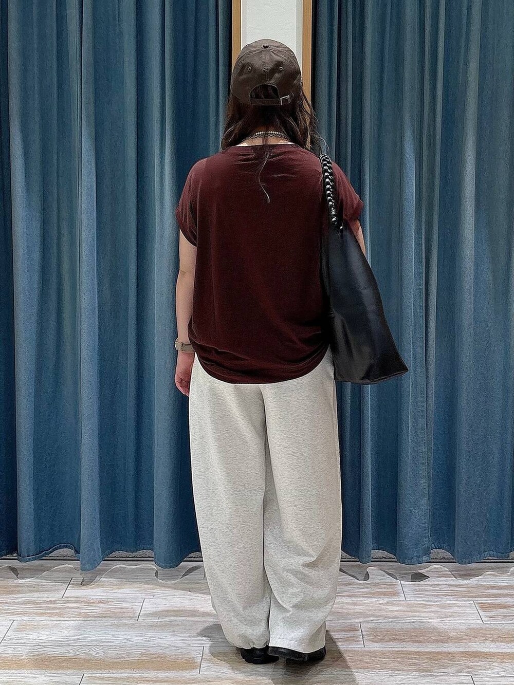 ブラック系のスニーカー、ブラウン系のTシャツ/カットソー、ベージュ系のスウェットパンツを着用したレディースの夏コーディネートの3枚目の写真