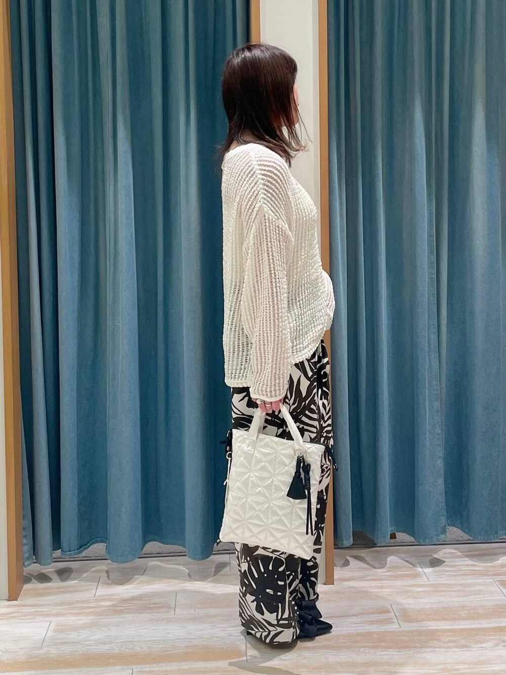 ブラック系のパンプス、ベージュ系のその他パンツ、ホワイト系のハンドバッグを着用したレディースの春コーディネートの2枚目の写真