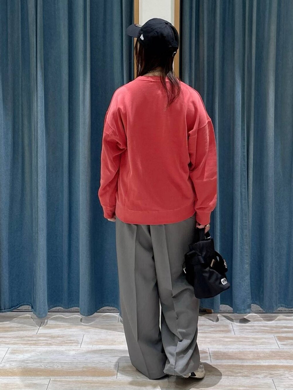 グレー系のその他パンツ、レッド系のスウェット、ブラック系のショルダーバッグを着用したレディースの秋コーディネートの3枚目の写真