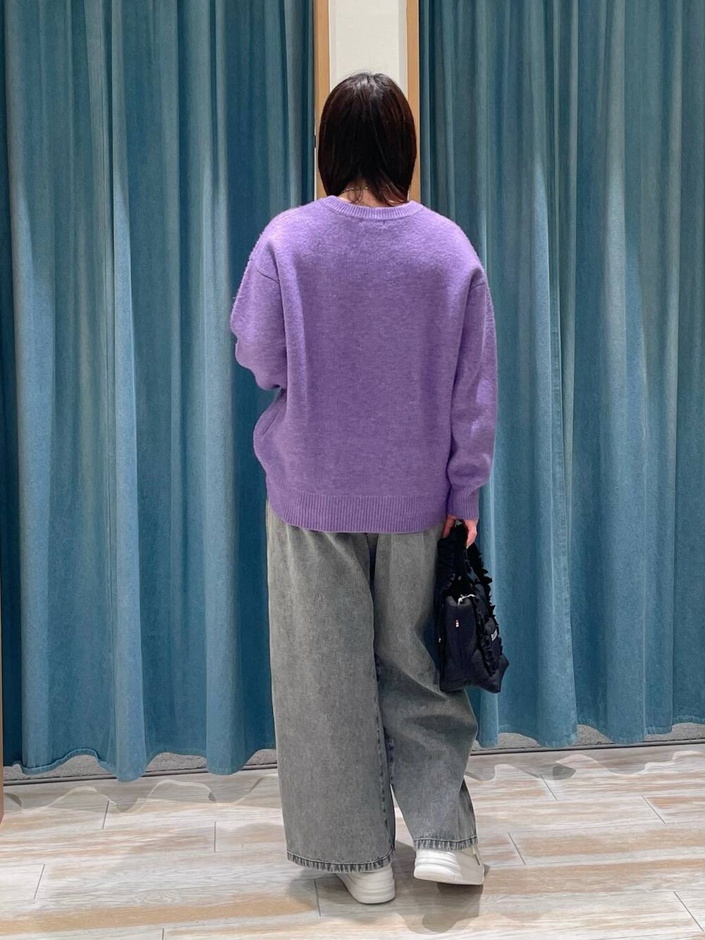 ホワイト系のスニーカー、ブラック系のトートバッグ、パープル系のニット/セーターを着用したレディースの冬コーディネートの2枚目の写真