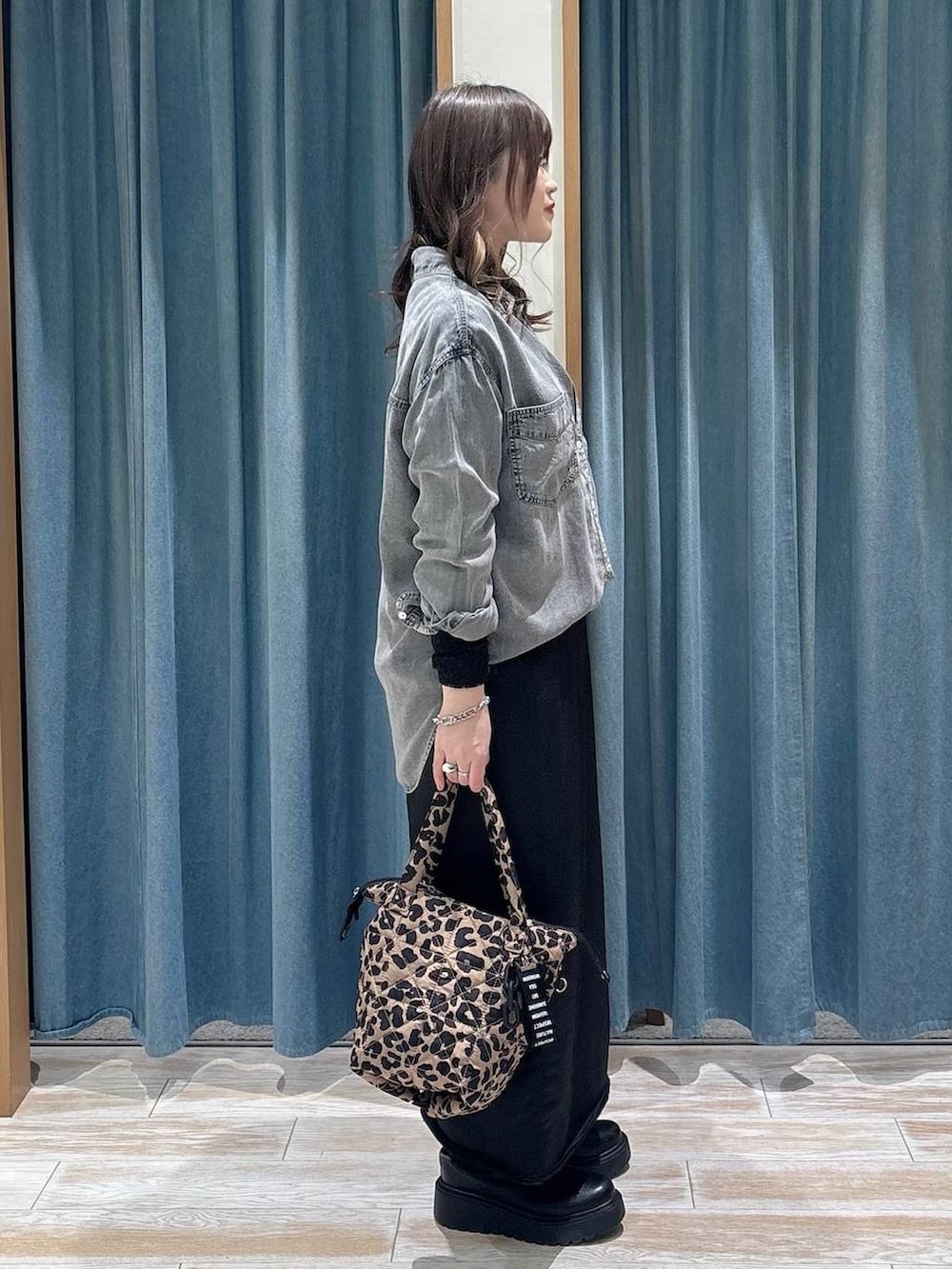 ブラック系のブーツ、ブラック系のTシャツ/カットソー、ブラック系のスカートを着用したレディースの冬コーディネートの2枚目の写真