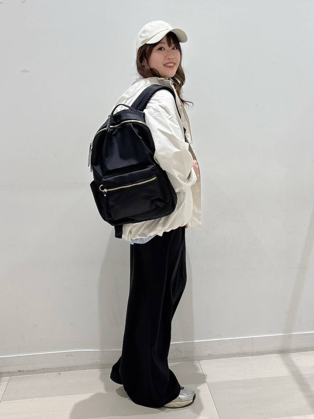 ブルー系のシャツ/ブラウス、ブラック系のバックパック/リュック、ベージュ系のマウンテンパーカーを着用したレディースの冬コーディネートの2枚目の写真