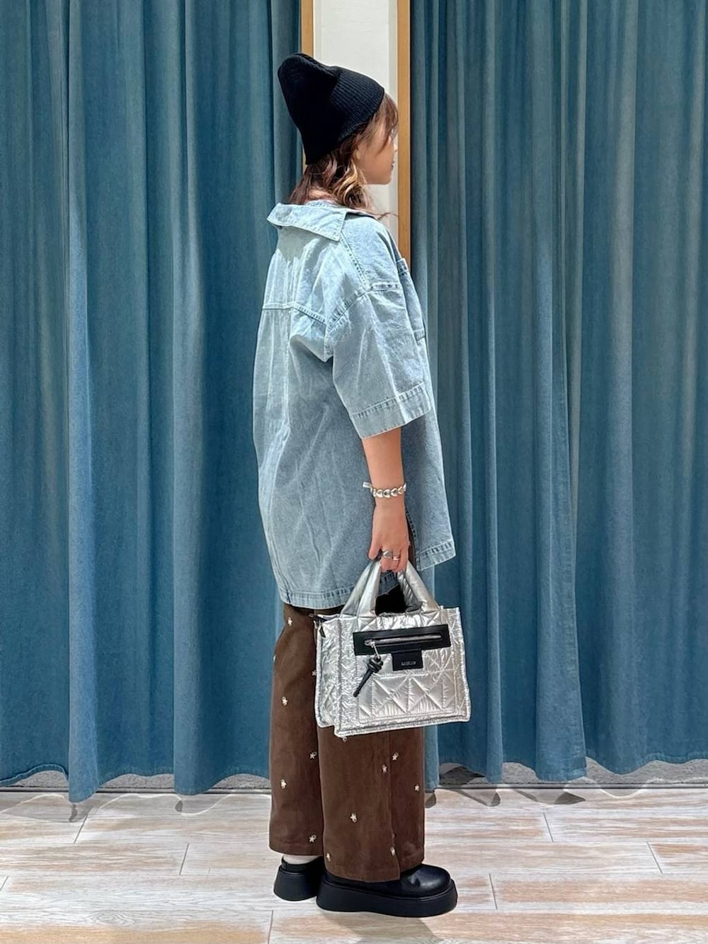 ブラック系のキャミソール、シルバー系のショルダーバッグ、ブラウン系のその他パンツを着用したレディースの秋コーディネートの2枚目の写真