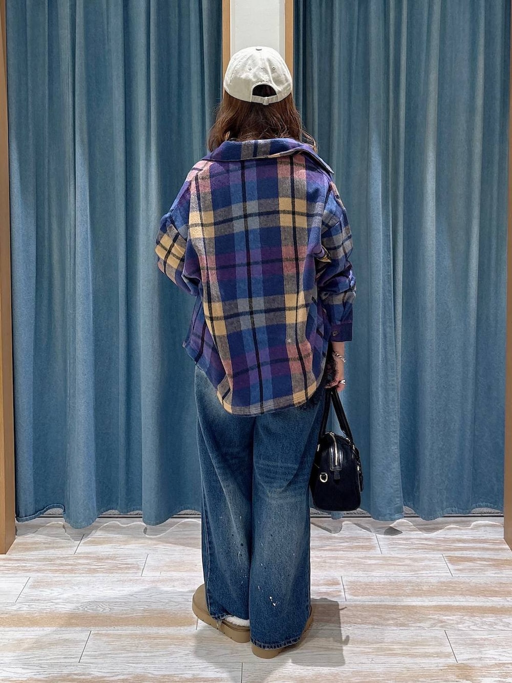 ベージュ系のその他シューズ、ブルー系のデニムパンツ、ブラック系のハンドバッグを着用したレディースの秋コーディネートの3枚目の写真