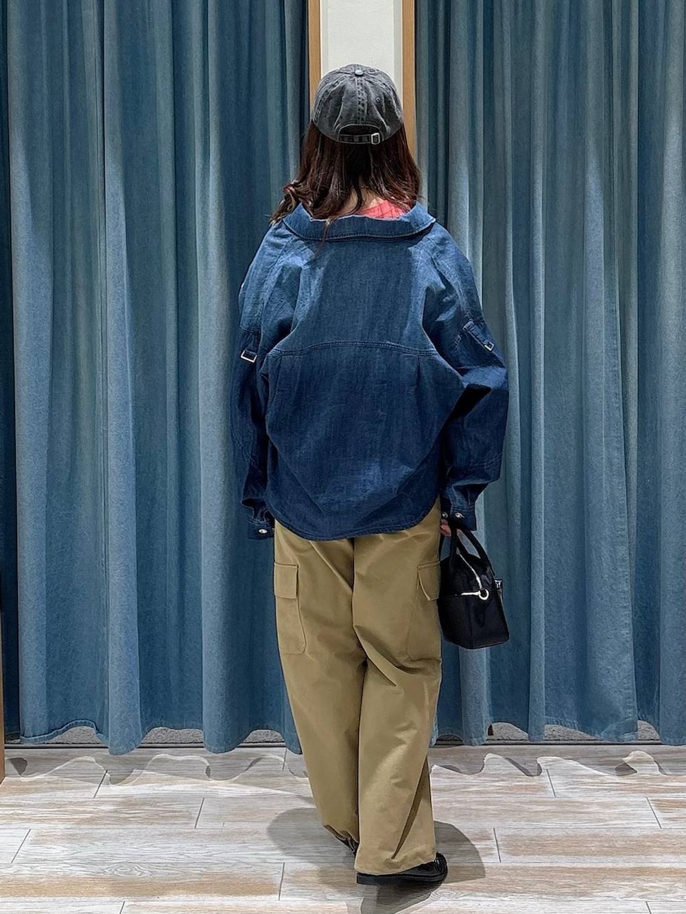 レッド系のTシャツ/カットソー、ブラック系のハンドバッグ、ブラック系のローファーを着用したレディースの冬コーディネートの2枚目の写真