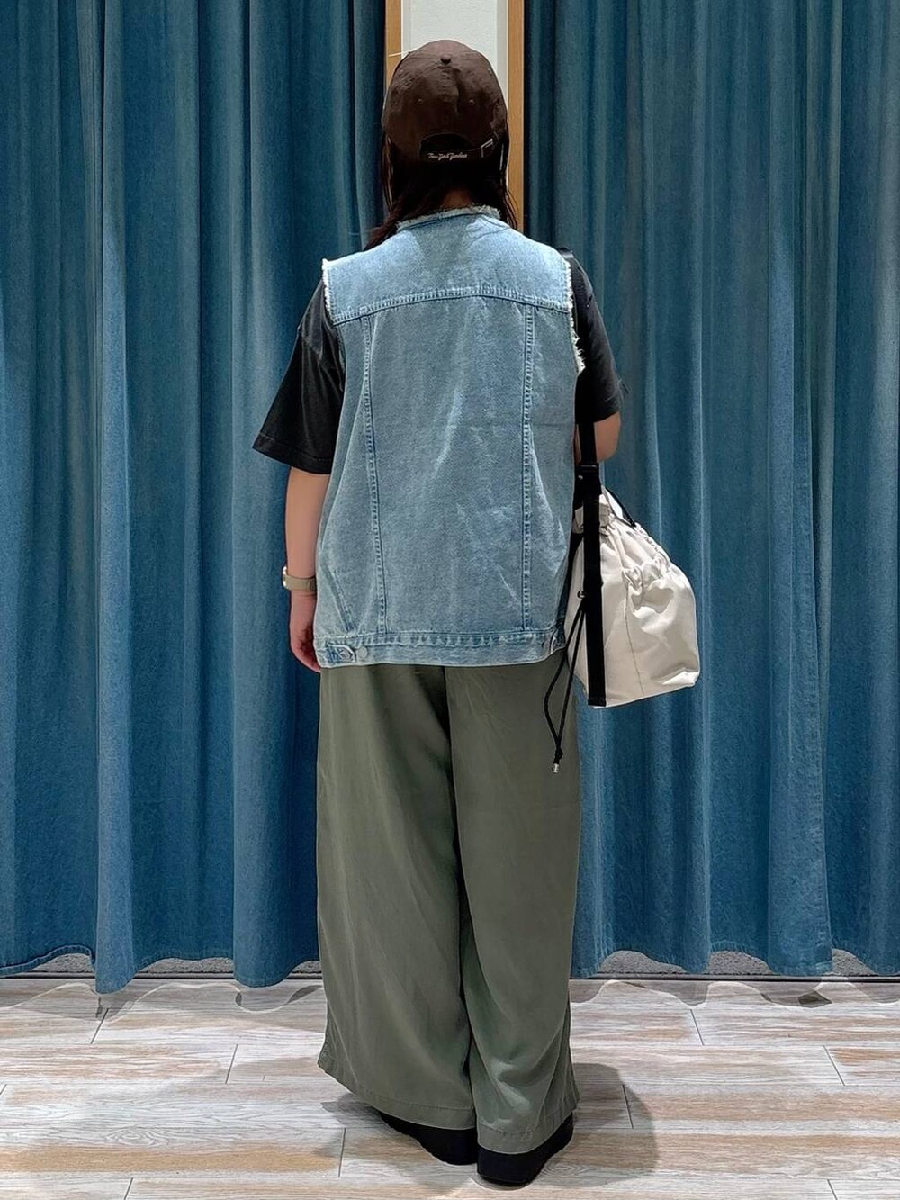ホワイト系のトートバッグ、グリーン系のその他パンツ、ブルー系のベストを着用したレディースの夏コーディネートの3枚目の写真