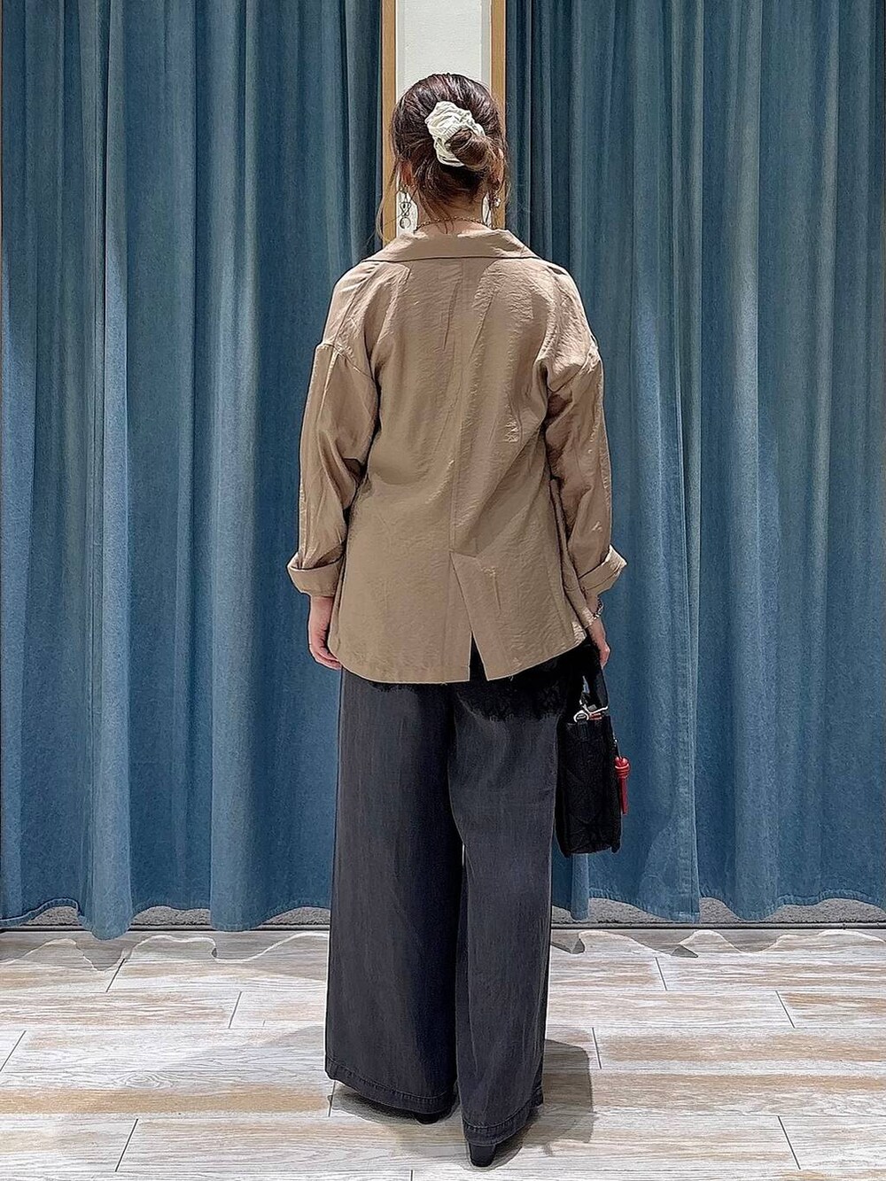 ブラック系のショルダーバッグ、ブラック系のデニムパンツ、ブラック系のキャミソールを着用したレディースの春コーディネートの3枚目の写真