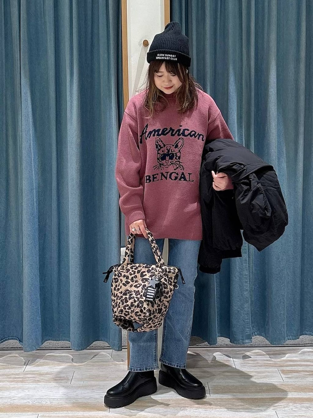 ブラック系のブーツ、ブラック系のダウンジャケット/コート、ピンク系のニット/セーターを着用したレディースの冬コーディネートの4枚目の写真