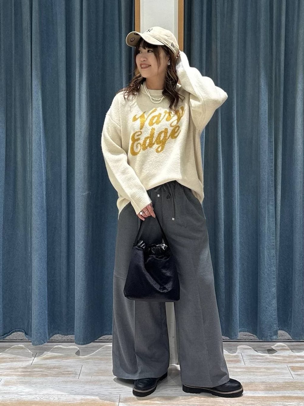 グレー系のその他パンツ、ブラック系のローファー、ホワイト系のニット/セーターを着用したレディースの秋コーディネートの4枚目の写真