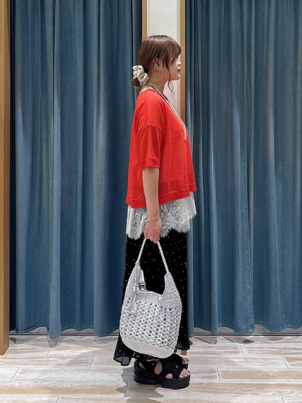 その他のスカート、レッド系のニット/セーター、シルバー系のショルダーバッグを着用したレディースの夏コーディネートの2枚目の写真