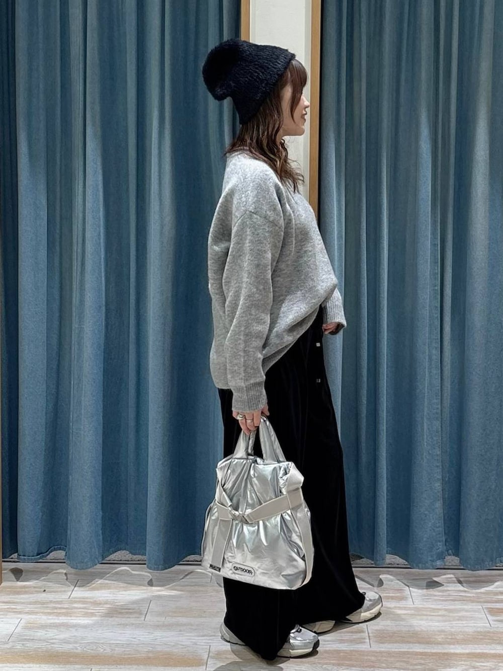 シルバー系のトートバッグ、ブラック系のその他パンツ、グレー系のニット/セーターを着用したレディースの秋コーディネートの2枚目の写真