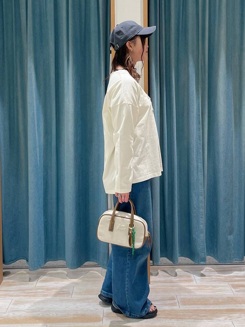 その他のショルダーバッグ、ブルー系のデニムパンツ、ブラック系のサンダルを着用したレディースの春コーディネートの2枚目の写真